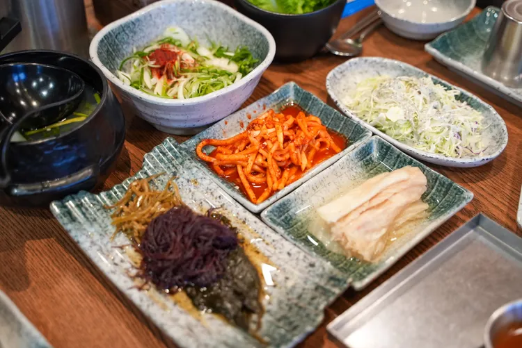 餐廳提供蔥絲沙拉、醃白菜辛奇、蘿蔔辛奇等小菜，自助無限續加。田欣雲攝影