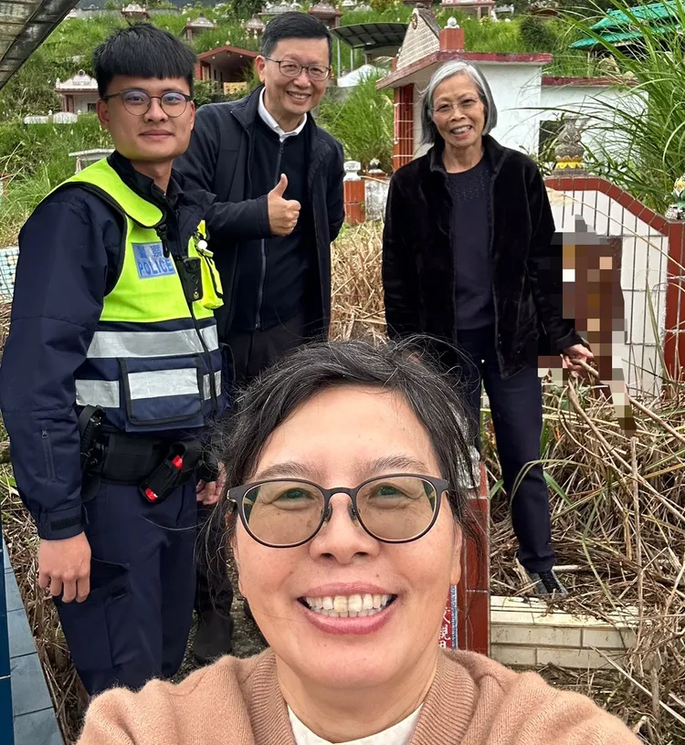 朱婦找到胞姊墳墓一解思親之愁，開心與帶路員警合影。警方提供