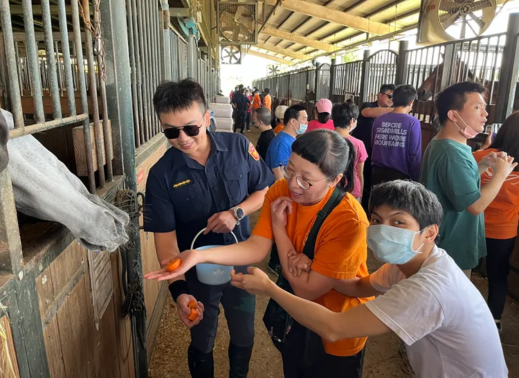 騎警隊員帶領障友們向馬匹餵食紅蘿蔔。警方提供