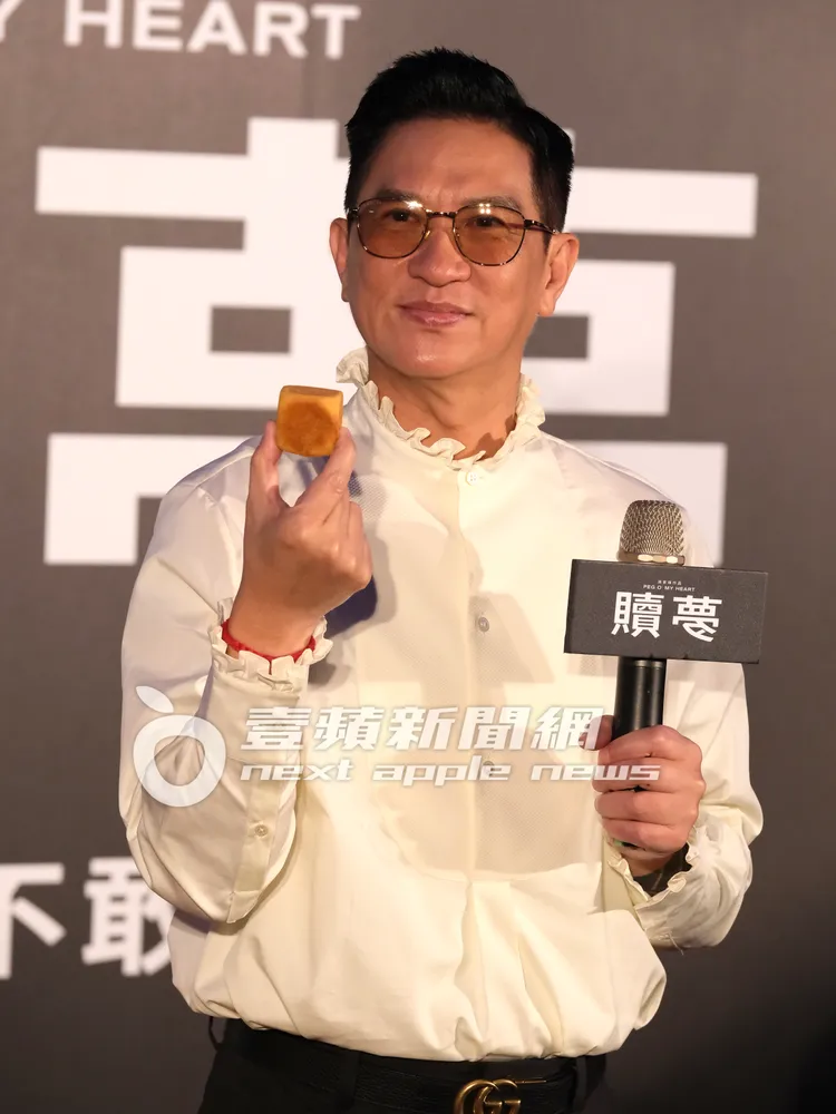 張家輝手拿台灣名產鳳梨酥，迫不及待咬一口。特勤中心攝