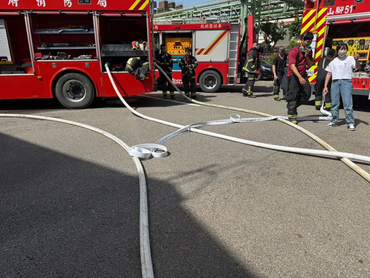 消防人員佈水線灌救。消防局提供