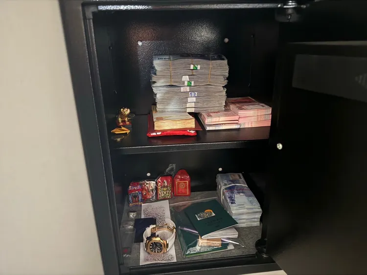 保險櫃中查扣整疊現金，還有價值300萬百達翡麗錶(圖下方)。翻攝畫面