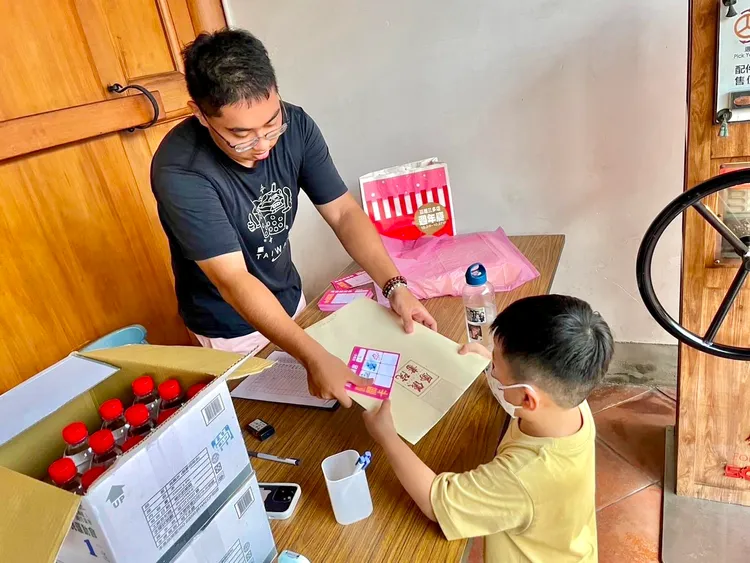 參加高市府暑期工讀的學生，在活動現場發放禮品給參觀民眾。高市青年局提供