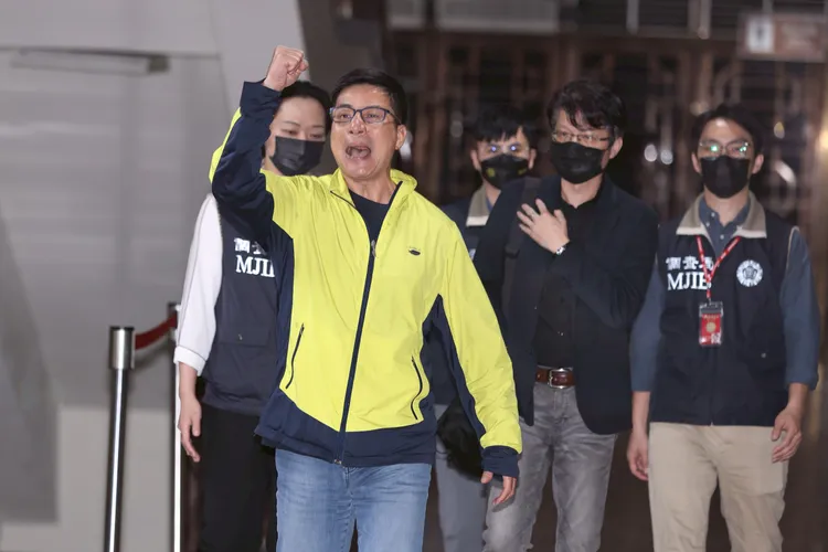 國民黨北市黨部總幹事姚富文被移送北檢時，高舉右手並高喊「台北霸雙吳、踴躍支持連署」。彭欣偉攝