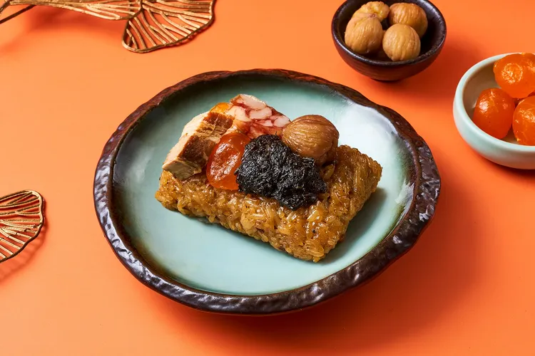 「欖香古法香肉粽」靈感源自港式糯米雞，融合欖菜、豬五花、香菇、栗子、臘腸與鹹蛋黃等食材，以秘製滷汁慢燉入味，傳遞道地廣東風味。新板希爾頓酒店提供