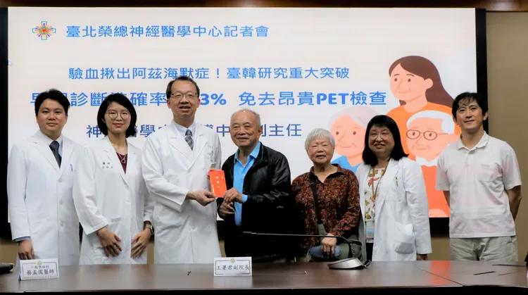 病友鄭先生(中)及家人與醫療團隊合影。台北榮總提供