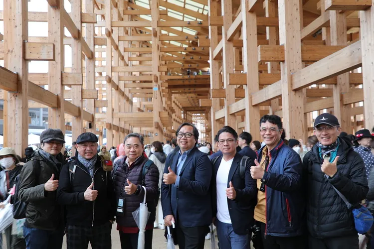 大阪世博13日正式開幕，許多台灣遊客搶在第一天體驗，建築師謝宗哲（右4）、結構技師陳冠帆（右3）等數十人就組團到世博觀看獲得金氏世界紀錄認證為全球最大木造建築的大屋頂環。 中央社