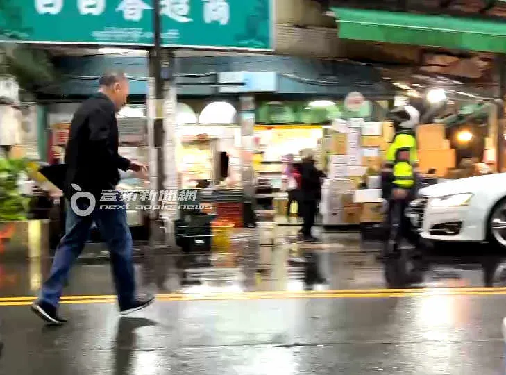 周永明（左）見警察要來開罰單，趕緊走回車上。特勤中心攝