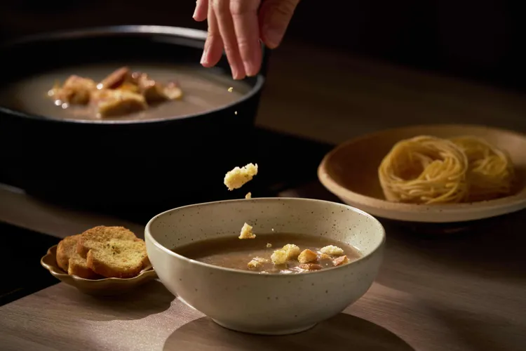 「松露野菇湯」上桌時會隨鍋附上香蒜麵包片，無論沾醬吃或捏碎成小麵包塊拌入湯中，都別有一番風味。業者提供