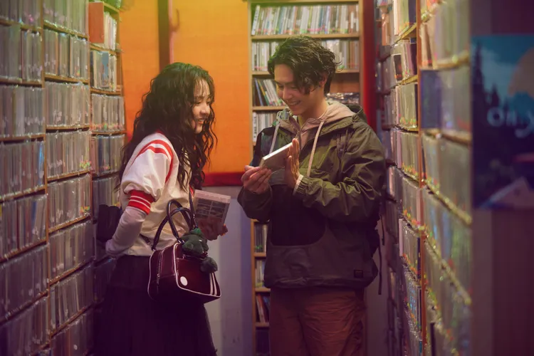 哲謙（右）飾演暖心客人，為林廷憶介紹好片。圖／相信音樂提供