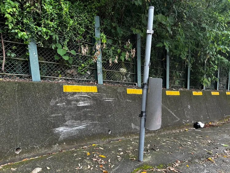 水泥護欄上留有機車的撞痕，指示牌也被撞歪。民眾提供