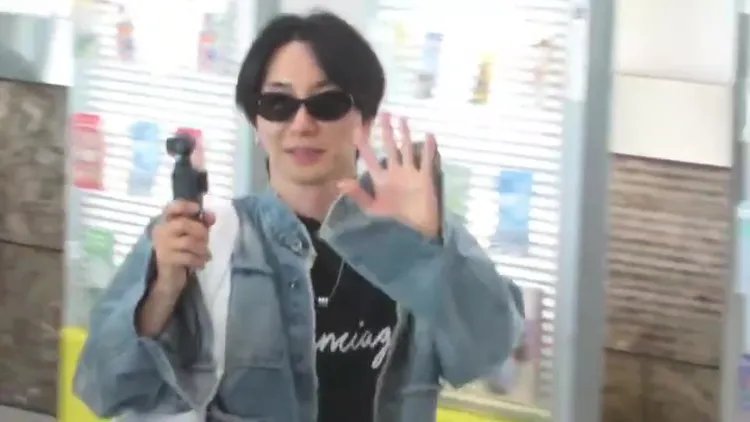 利特踏出小港機場，拿著相機拍攝影片。讀者提供