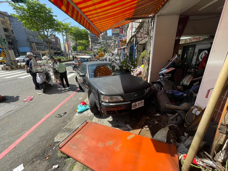 黑色轎車失控倒車，當場撞上一部雙載機車。葉先鵬攝