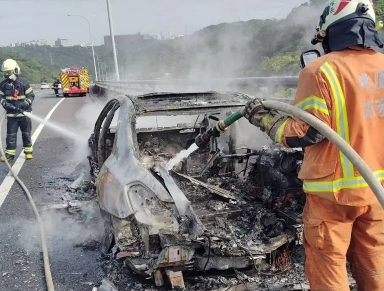 車後輪突然起火瞬間蔓延到全車，駕駛逃生，消防人員到場灌救。翻攝畫面