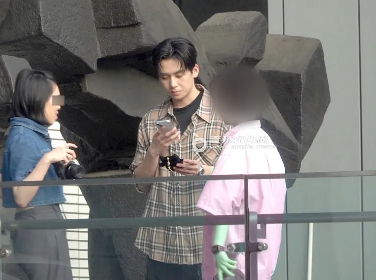 葛兆恩（中）拿起手機拍攝粉絲特別做的小卡。粉絲衣服經變色處理／特勤中心攝