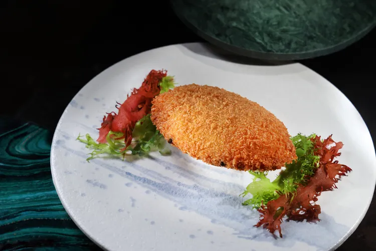 「麗晶軒」的招牌料理「脆釀鮮蟹蓋」凝聚粵菜精髓，將手工拆取的細緻鮮蟹肉填入蟹蓋中油炸至香脆金黃，展現香酥與嫩滑的雙重口感。台北晶華提供