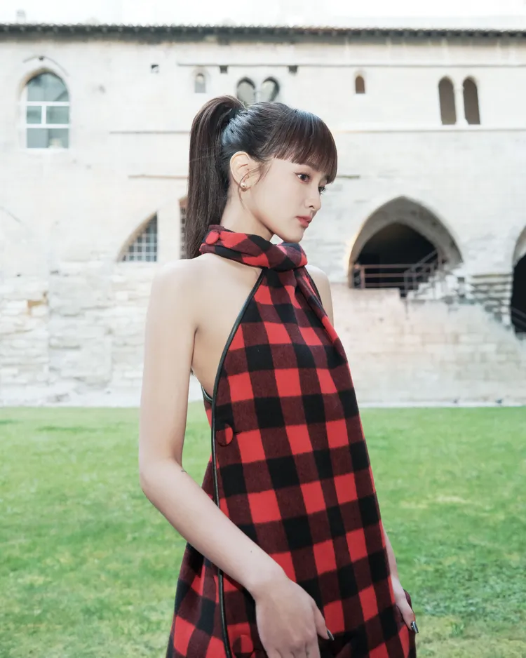 王淨綁著高馬尾，身著大膽撞色格紋裙露香肩超吸眼球。狗狗與花提供