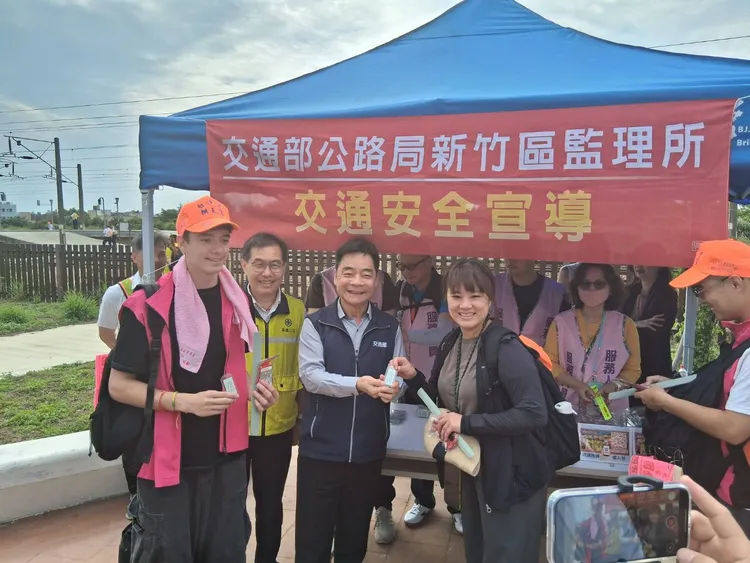 交通部次長伍勝園到台鐵白沙屯車站，發放疏運平安守給現場民眾。交通部提供