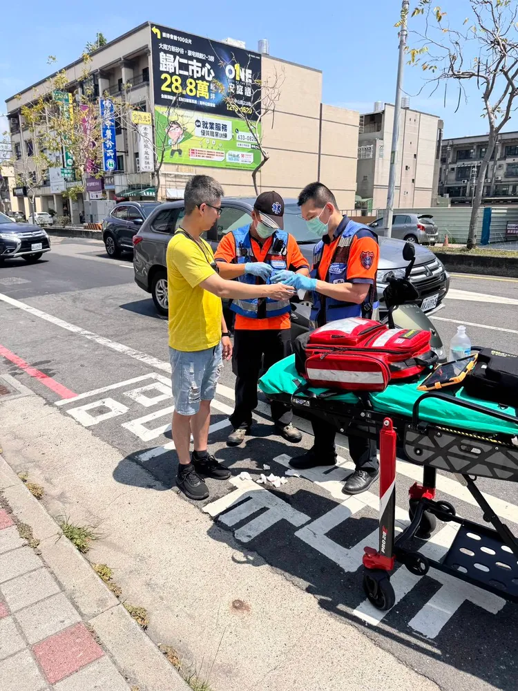 林姓警員（黃衣）破窗控制車輛，手部遭玻璃割傷，經119人員現場包紮，所幸無大礙。翻攝畫面