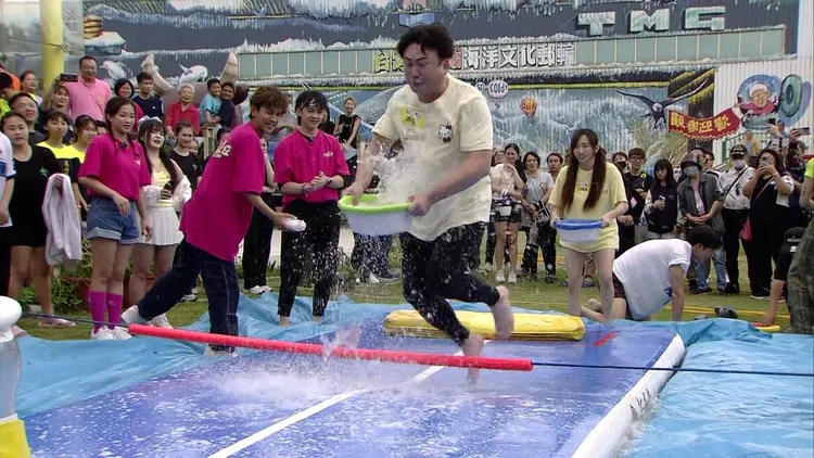 洪毛（中）手捧裝滿水的水盆，拼命往前跑。民視提供