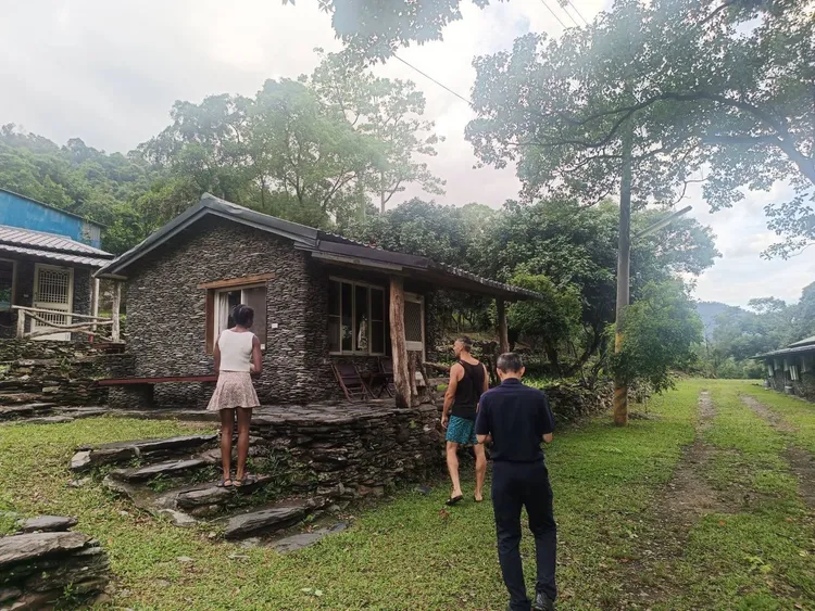 外籍情侶對布農族傳統建築板岩屋非常有興趣。翻攝畫面