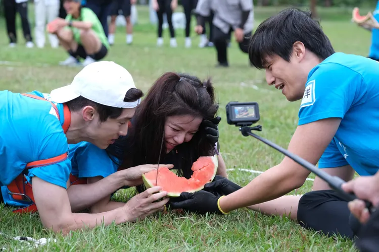 啦啦隊女神凱蒂（中）奮力啃咬西瓜，卻不慎咬傷徐新洋（右）的手指。東森綜合台提供
