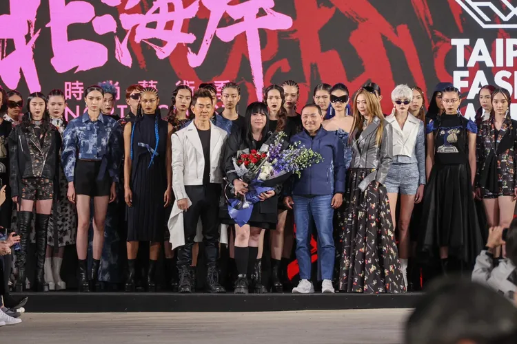 潘怡良(圖中黑衣者)多次與新北市政府合作，曾把「臺北時裝週」移師淡水漁人碼頭造成轟動，此次為壽司店跨刀，設計李多慧店長服裝。翻攝自新北市府網站