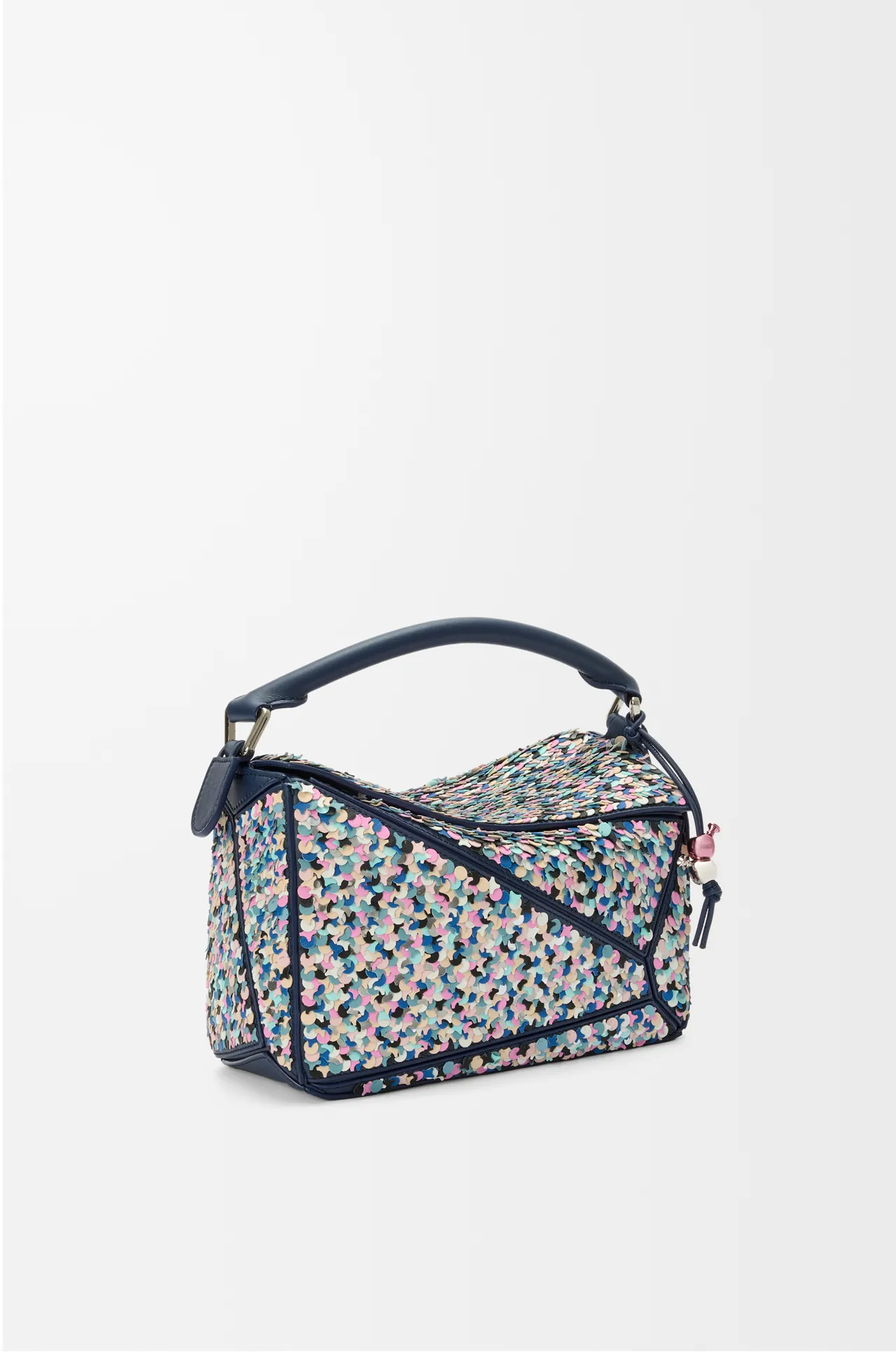 LOEWE 為慶祝 Puzzle 包款十週年,推出全新 Puzzle 10 Confetti 版本,這款設計以手工刺繡的數千塊彩色小皮塊和銀色珠片裝飾包身,呈現歡快繽紛的視覺效果 。品牌提供