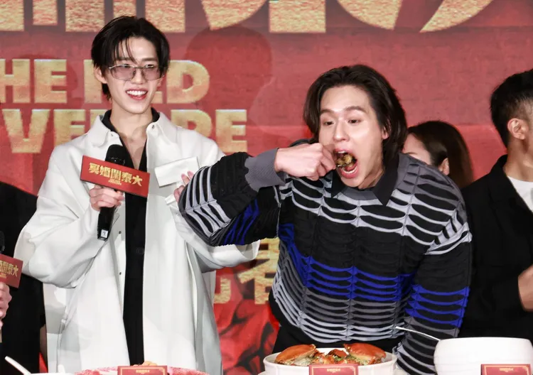 Billkin（右）吃到停不下來，趁空檔偷挖一口紅蟳米糕，一旁的PP露出欣慰的笑容。攝影中心攝