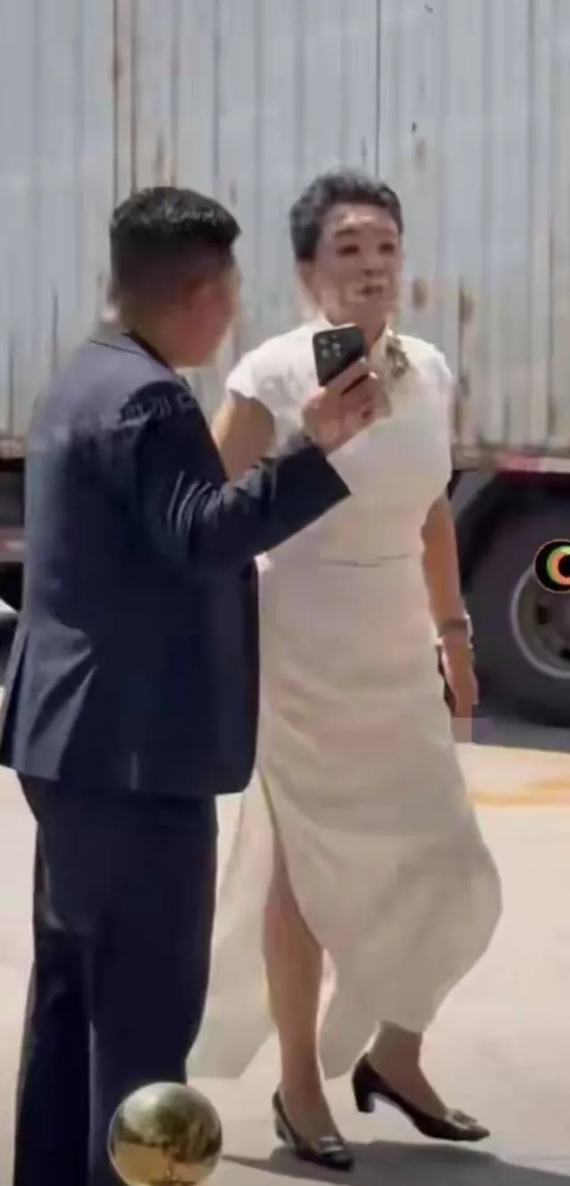 張蘭今天穿著白色旗袍出席兒子婚禮，看起來有點顯胖。翻攝董克川微博