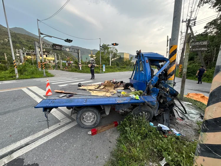 小貨車撞路邊紅綠燈號誌桿車頭凹陷，坐在後車斗的2人飛出路面慘死，車上赫見獵槍及獵物。民眾提供