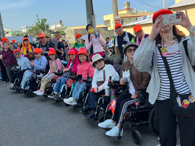 來自新北市的一群輪椅族來追粉紅超跑。民眾提供