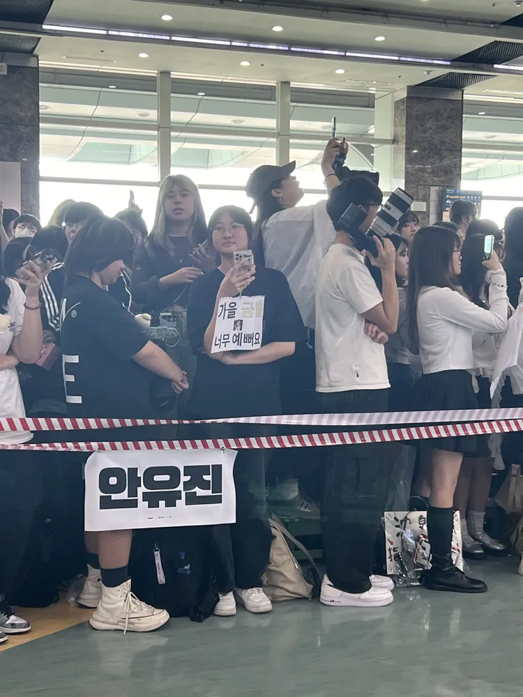 IVE粉絲做了安俞真的名牌，手裡拿著「秋天金髮真漂亮」的牌子。陳薇安攝