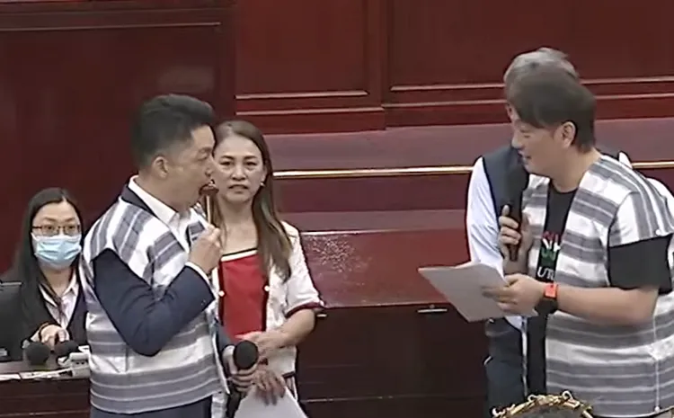 蔣萬安議會穿達悟族服、嗑香腸，笑參與文化推廣活動。翻攝台北市議會直播