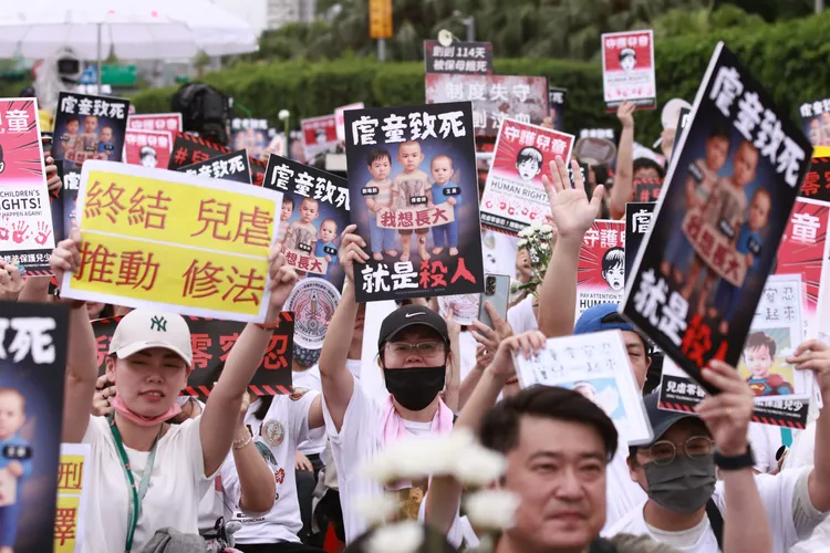 民眾高舉標語籲政府修法。彭欣偉攝