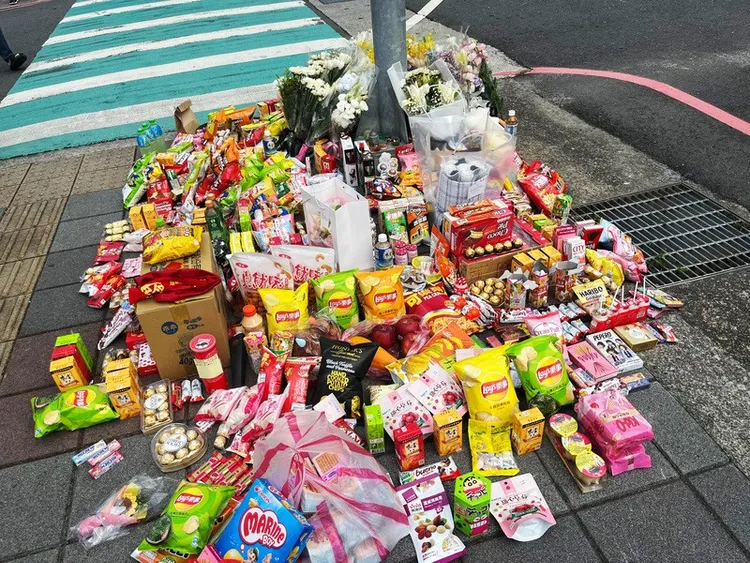 零食與鮮花擺滿路旁電線桿。中央社