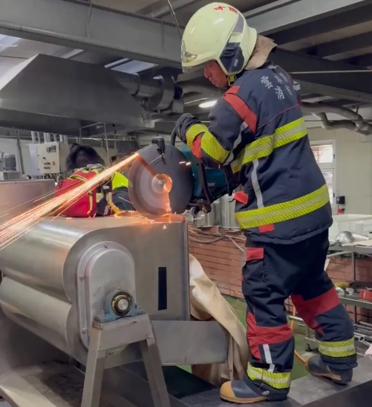 消防人員以電鋸破壞機械救人。民眾提供