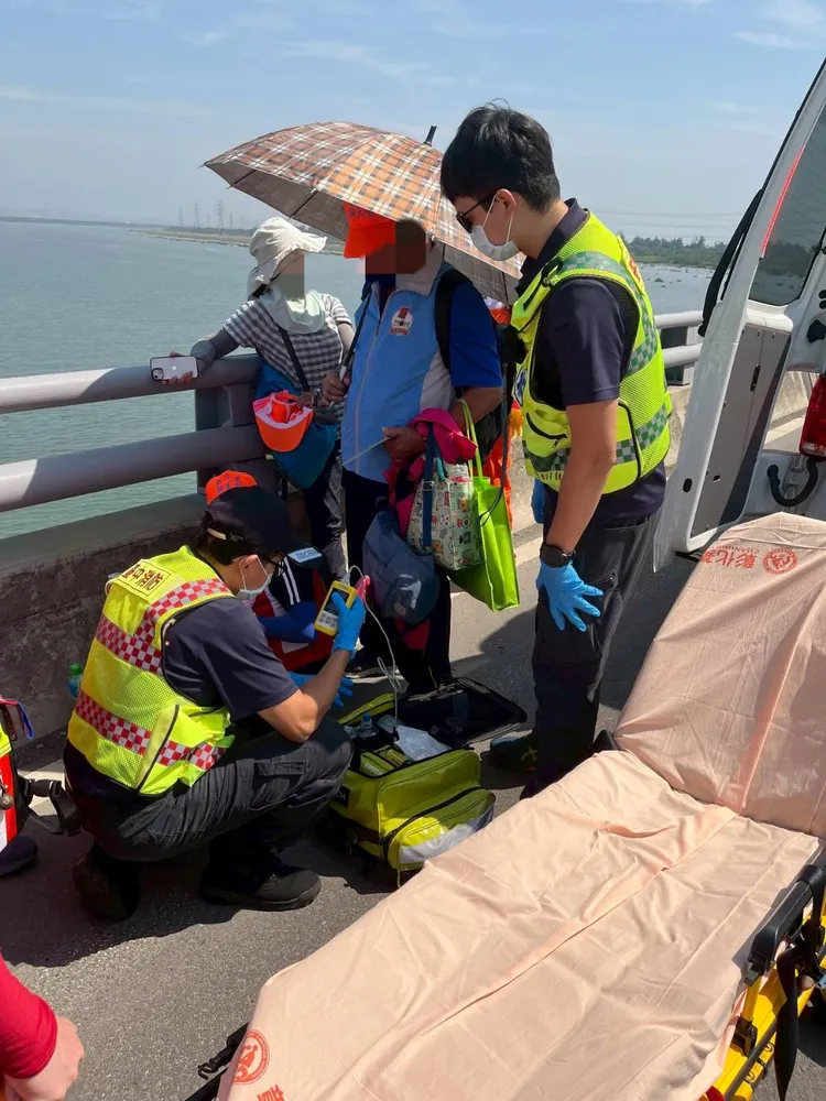 警方在中彰大橋發現1名香燈腳疑似中暑坐地上，立即上前協助並通報救護車。民眾提供