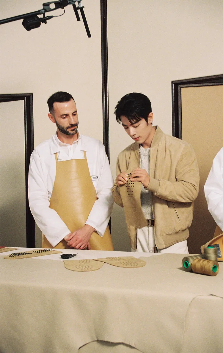 肖戰專心看著手上的布料，專注樣貌超帥。品牌提供