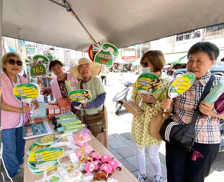 北檢在新店建國路市場設反詐騙宣導攤位，發放精美宣導品與反詐文宣。北檢提供