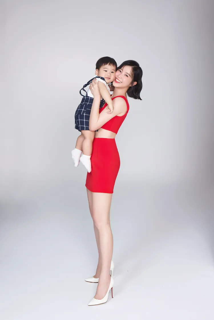李佳穎穿著紅色火辣兩截式洋裝，抱著嫩嬰合影，大露筆直長腿與極細腰線。美体專科提供