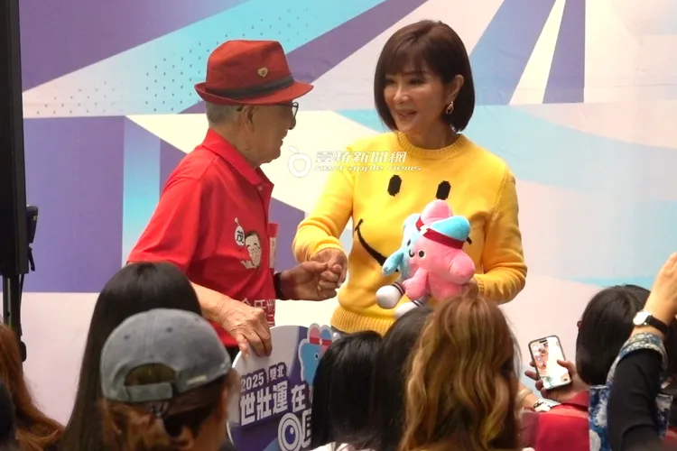 陳美鳳（右）手拿著2025雙北世壯運吉祥物「壯寶」，跟人瑞選手互動。特勤中心攝