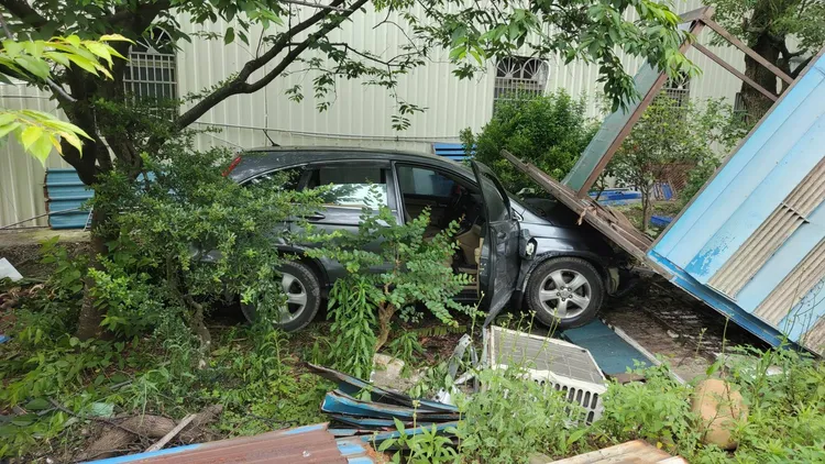 肇事轎車一路衝到檳榔攤前草叢，但駕駛逃逸無蹤。翻攝畫面