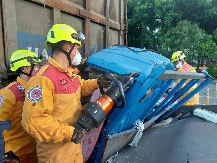 消防人員以破壞器材搶救受困的小貨車駕駛。民眾提供