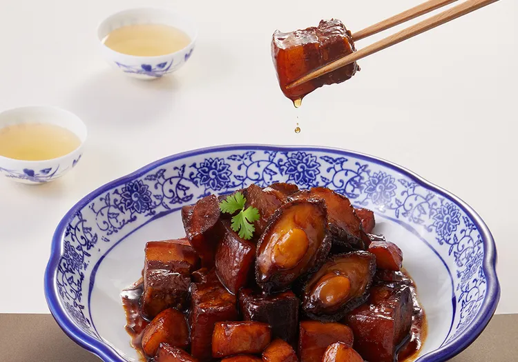 「鮑魚紅燒肉」以五花肉與鮮筍、鮑魚同燒，慢火滷製至醬色紅亮、肉酥不碎。搭配紹興酒與老抽，甜鹹適中、膠質滿溢，為經典紅燒技藝的代表作。業者提供