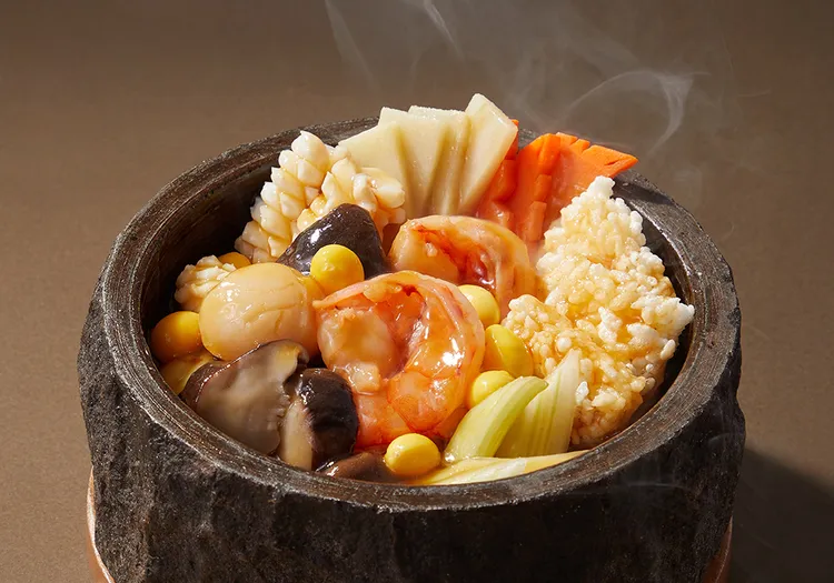 「火山石鍋巴三鮮」以蝦仁、魚片、魷魚佐特製高湯煨煮，搭配台南後壁米烹煮成鍋巴，盛於火山石鍋中上桌，熱湯澆淋瞬間「滋滋」作響，香氣四溢。業者提供