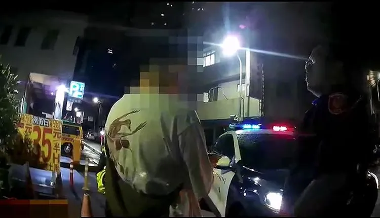 酒醉持雨傘在街頭攻擊人車的王姓男子，被警方帶回派出所。民眾提供