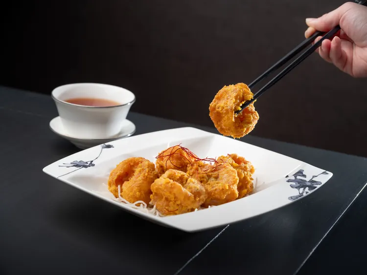 「金沙蝦球」1580元+10%，主廚選用滑嫩鮮蝦裹漿酥炸，其裹漿為主廚獨門巧思，以蛋白取代傳統蛋黃或全蛋製漿油炸，炸衣酥薄不厚重，口感更為鬆脆清爽。台北文華東方酒店提供