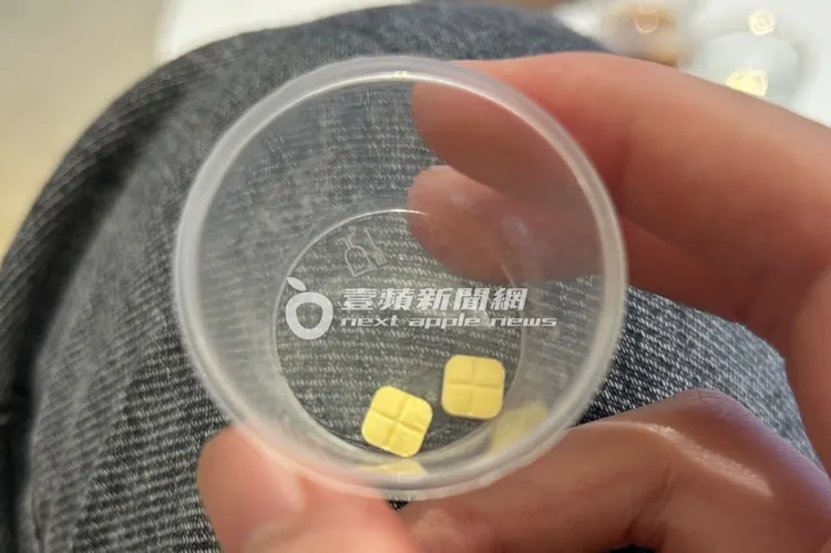 診所營運總監拿2顆黃色藥丸宣稱具止痛作用給記者服用。特勤中心攝