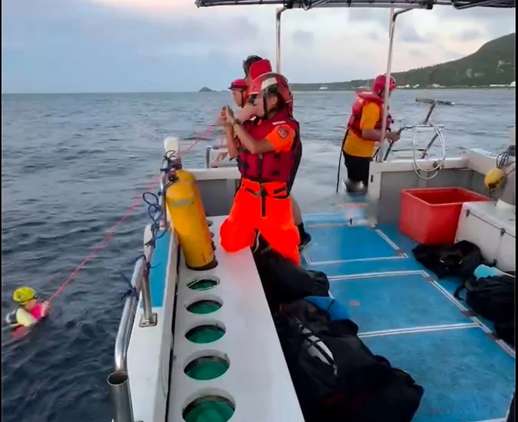 海巡隊員將體力不支的遊客救上船。海巡署第13岸巡隊提供。
